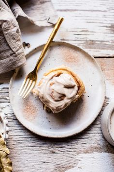 a white plate topped with a pastry covered in frosting