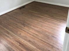 an empty room with hard wood flooring and white paint on the walls is seen in this image