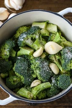 broccoli and garlic are mixed together in a pot on the table with other vegetables