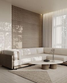 a living room with a large white couch and coffee table in front of a window