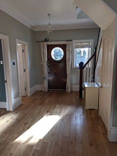 an empty living room with wood floors and a door leading to the front entrance area