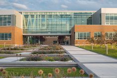 a large building with many windows and plants in the front