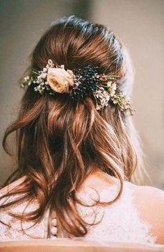 the back of a woman's head with flowers in her hair, wearing a wedding dress