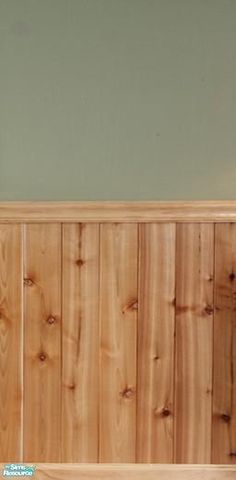 a wooden headboard sitting on top of a bed next to a green painted wall