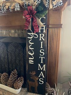 a wooden sign that says merry christmas and some pine cones on the fireplace mantel