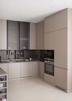 a modern kitchen with stainless steel appliances and white counter tops, along with beige cabinets