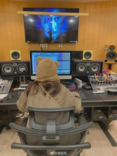 a person sitting at a desk in front of a computer monitor with headphones on