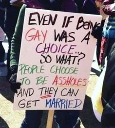 a person holding a sign that says, even if being gay was 4 choice so what? people choose to be asked and they can get married