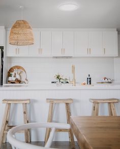 a kitchen with white cabinets and wooden stools