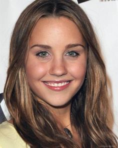 a close up of a person with long hair and blue eyes smiling at the camera