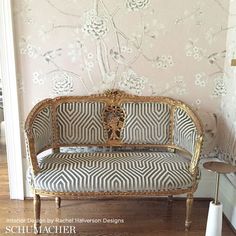 a couch sitting on top of a hard wood floor next to a wall with flowers