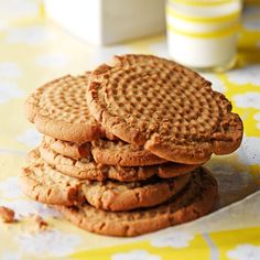 a stack of cookies sitting on top of a table next to a glass of milk