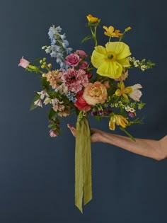 a person holding a bouquet of flowers in their hand