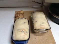 two loafs of bread sitting on top of a counter next to a cookie sheet