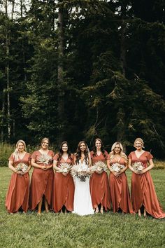 a group of women standing next to each other on top of a lush green field