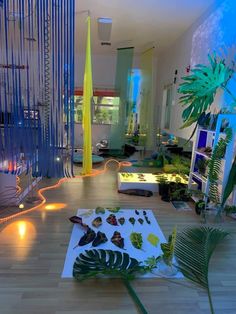 a living room filled with lots of furniture and plants on top of a hard wood floor