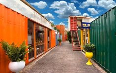 there are many colorful shipping containers lined up along the street with stairs leading to them