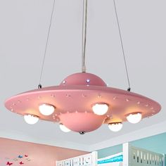 a pink ceiling light hanging over a child's room