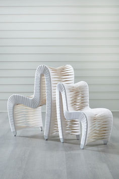 three white chairs sitting on top of a wooden floor