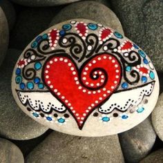 a rock with a heart painted on it surrounded by rocks and stones in the shape of hearts