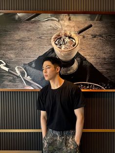 a young man standing in front of a painting