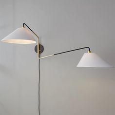 two lamps are on the wall next to each other, one is white and the other is black