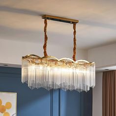 a chandelier hanging from the ceiling in a room with blue walls and curtains