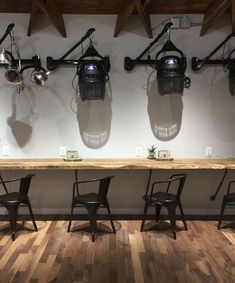 a row of chairs sitting next to a wooden table on top of a hard wood floor