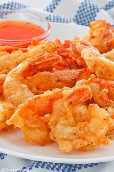 a white plate topped with fried shrimp and dipping sauce