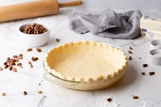 an uncooked pie sitting on top of a table next to other baking supplies