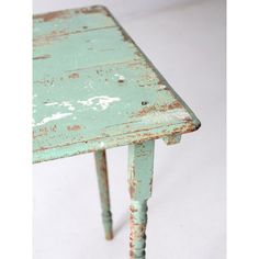 an old wooden table with peeling paint on the top and bottom edge, sitting against a white background