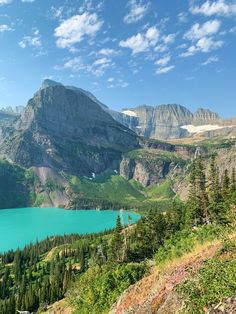 a scenic view of a mountain lake and its surrounding mountains with blue water in the foreground