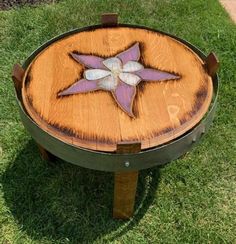 a wooden table sitting in the grass with a star painted on it's side