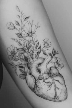 a black and white photo of a heart with flowers on the inside of its arm