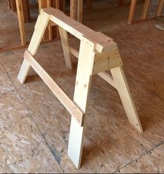 a wooden bench sitting on top of a floor next to plywood planks in a room