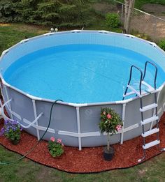 an above ground swimming pool with ladders on the side and flowers growing in it