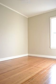 an empty room with hard wood floors and white walls