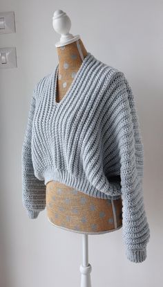 a knitted sweater on a mannequin with polka dots in grey and white