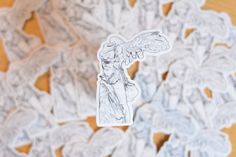 an angel sticker sitting on top of a wooden table next to paper cut outs