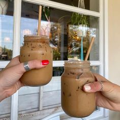 two people hold up mason jars with strawberries in them, one is filled with chocolate and the other has sprinkles