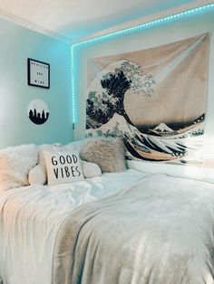 a room with a bed, pillows and a tapestry on the wall above it that says good vibes