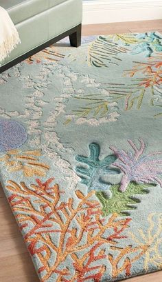 an area rug with various colored corals and seaweed on it in a living room