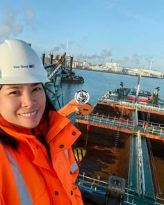 a woman in an orange jacket and hard hat