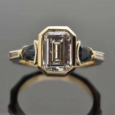 14kt Yellow Gold Diamond and Green Sapphire Ring. This geometric design features a large bezel-set emerald cut diamond with a trillion cut green sapphire and a diamond baguette on each side. This item is a custom order only. Price is for the ring setting only. The stones will be priced separately. The completion of the item will take about 20 - 30 days. You can use your own center stone or request a quote for stones from our inventory. Please provide the ring size or we will make it an average s Luxury Emerald Baguette Cut Bezel Set Ring, Mid Century Engagement Ring, Bezel Set Engagement Ring, Vintage Art Deco Rings, Saphir Ring, Green Sapphire Ring, Diamond Baguette, Future Engagement Rings, Emerald Cut Diamond