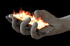 a person holding a cell phone in their hands with fire coming out of the screen