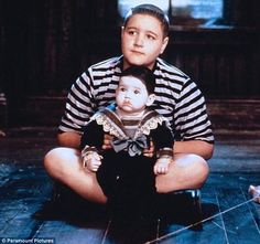 a man sitting on the floor holding a baby