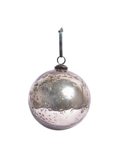 a silver ornament hanging from a metal hook with water droplets on the surface