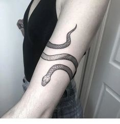 a woman's arm with a snake tattoo on it