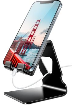 an image of a cell phone charging on a stand with the golden gate bridge in the background