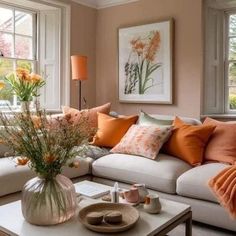 a living room filled with lots of furniture and flowers on top of a coffee table